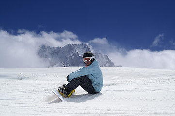 Image showing Snowboarder resting on the ski slope