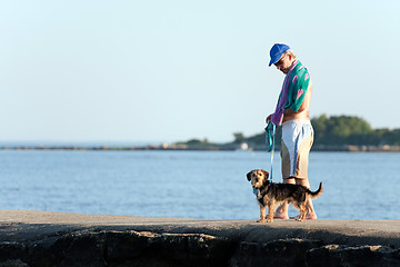 Image showing Middle Aged Man Walking His Dog