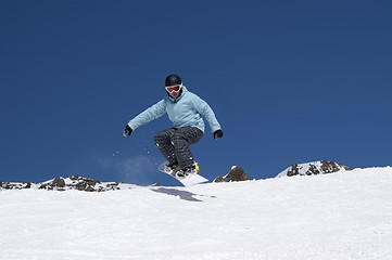 Image showing Snowboarder jumping in the mountains