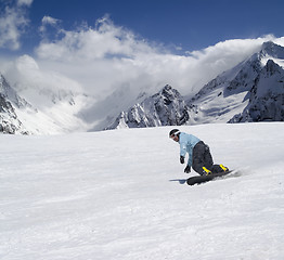 Image showing Snowboarder descends a slope