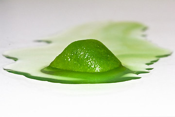 Image showing Gooish green ice cube melting