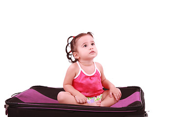 Image showing cute little girl sitting on the black suitcase 