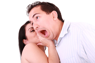 Image showing Woman tells something into surprised guy's ear isolated on white