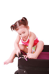 Image showing Little girl in a suitcase. Isolated on a white background 