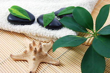 Image showing foldet white bath towel and zen stones