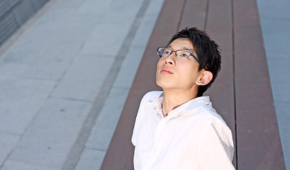 Image showing Young caucasian businessman sitting on bench