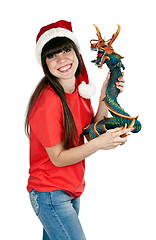 Image showing Girl in Santa hat with a decorative wooden dragon