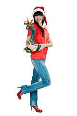 Image showing Girl in Santa hat with a decorative wooden dragon