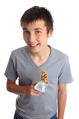 Image showing Smiling boy holding muesli bar