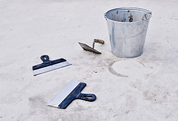 Image showing metal bucket with cement and spatulas