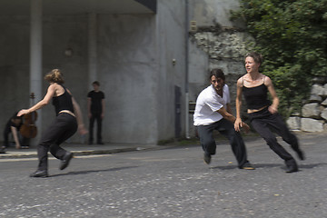 Image showing Three dancers run in the street