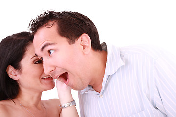 Image showing girl tells something into surprised guy's ear isolated on white 