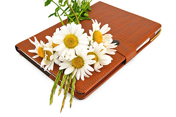 Image showing Notebook with pen and daisies