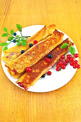 Image showing Pancakes with blueberries and red currants on the board