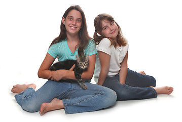 Image showing Two Sisters Holding Their Young Kitten