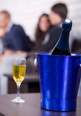 Image showing Champagne in focus, couples in background