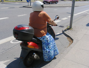 Image showing Senior riding a moped.