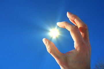 Image showing hand fingers sky and sun