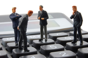 Image showing toy business man on calculator isolated 