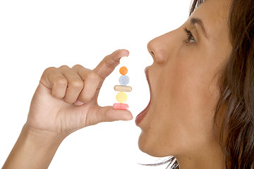 Image showing young women pops a pill into her mouth