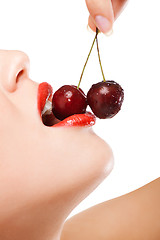 Image showing young woman's mouth with red cherries