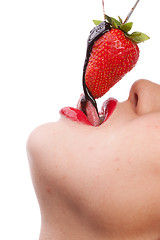 Image showing girl eating strawberry with chocolate sauc