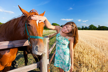 Image showing horse and blond girl in paddock on summers