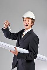 Image showing smiling engineer giving keys from apartment