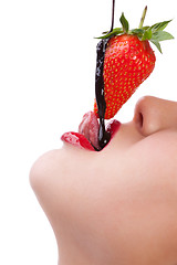 Image showing girl eating strawberry with chocolate sauc