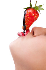 Image showing girl eating strawberry with chocolate sauc