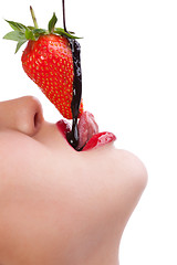 Image showing girl eating strawberry with chocolate sauc