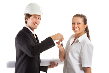 Image showing smiling engineer giving keys from apartment