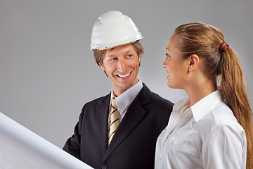 Image showing An architect wearing a hard hat and co-worker