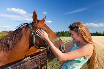 Image showing horse and blond girl in paddock on summers