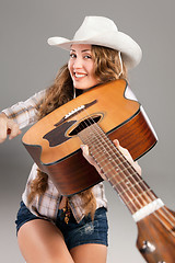 Image showing Sesy cowgirl in cowboy hat with acoustic guitar