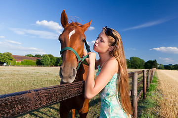 Image showing horse and blond girl in paddock on summers