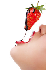 Image showing girl eating strawberry with chocolate sauc