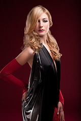 Image showing Perfect blonde in a black dress on red