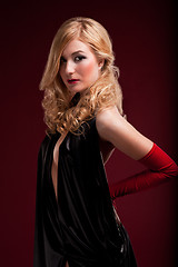 Image showing Perfect blonde in a black dress on red