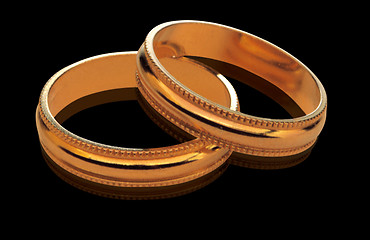 Image showing two golden wedding rings isolated on black