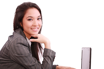 Image showing beautiful smiling business woman working on laptop 