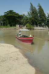 Image showing Small, red motorboat at the beach