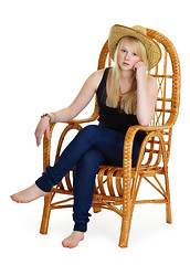 Image showing dreamy girl is sitting in a wicker chair