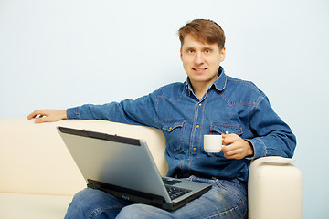 Image showing Person reads news in Internet at home on sofa