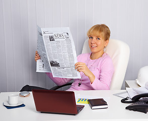 Image showing Young woman reads news on the workplace