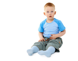 Image showing Surprised little boy sitting on white