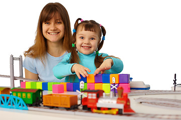 Image showing Young mother and daughter playing with toys