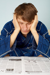 Image showing Sad man reading a newspaper