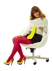 Image showing Young woman reads document in white chair