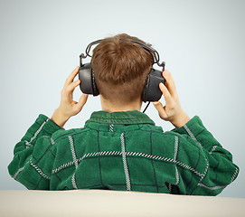 Image showing Man listens to symphonic music at home on couch